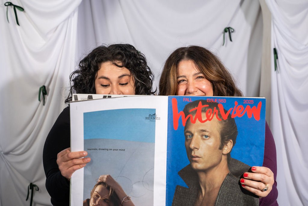 Peeking over a copy of Interview magazine